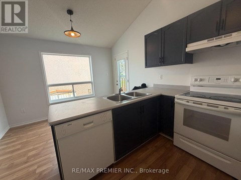 A kitchen with black cabinets and a white stove top oven.