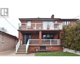 A two-story brick house with a balcony on the second floor.