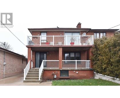 A two-story brick house with a balcony on the second floor.