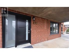 A black door is on the left side of a brick wall.