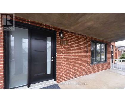 A black door is on the left side of a brick wall.