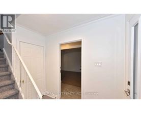 A white door with a small window in the middle of a hallway.