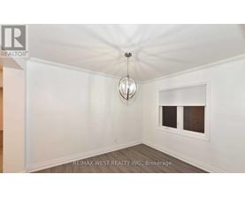 A room with a window and a hanging light fixture.