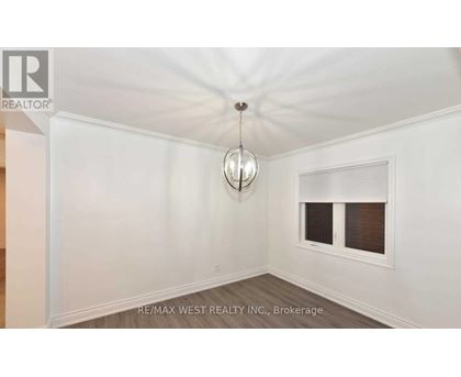 A room with a window and a hanging light fixture.