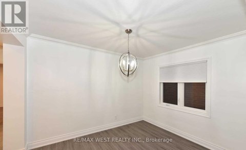 A room with a window and a hanging light fixture.