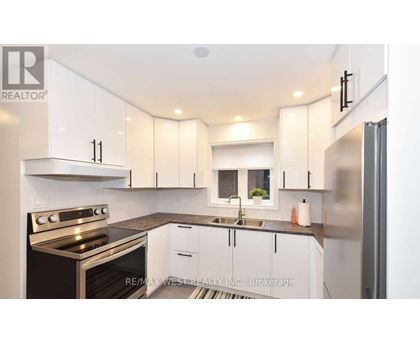 A modern kitchen with white cabinets and stainless steel appliances.
