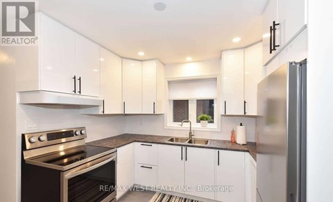 A modern kitchen with white cabinets and stainless steel appliances.