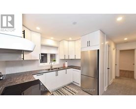 A modern kitchen with white cabinets and a stainless steel refrigerator.