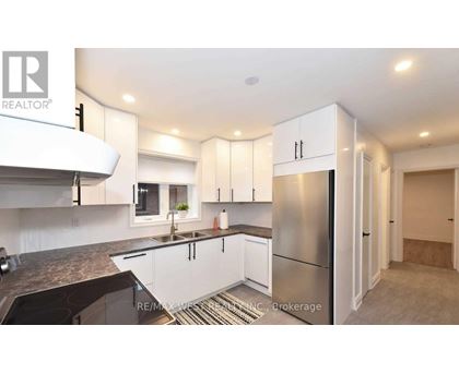 A modern kitchen with white cabinets and a stainless steel refrigerator.