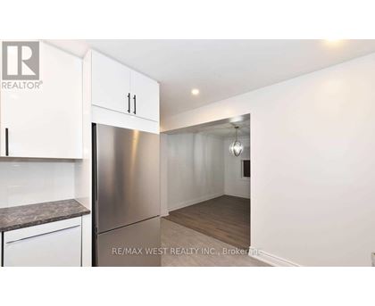 A kitchen with white cabinets and a stainless steel refrigerator.