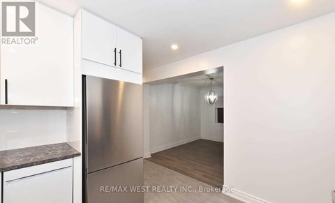 A kitchen with white cabinets and a stainless steel refrigerator.