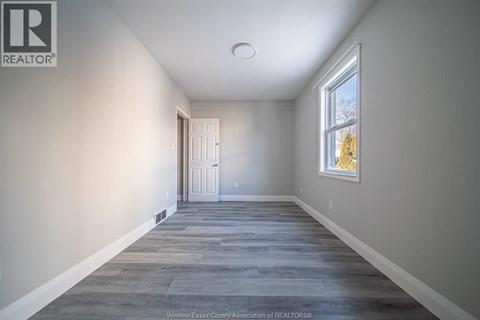 A long, empty hallway with a door at the end.