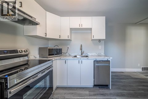 A kitchen with white cabinets and stainless steel appliances.