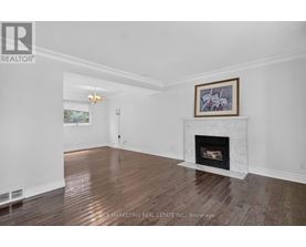 A living room with a fireplace and a painting above it.