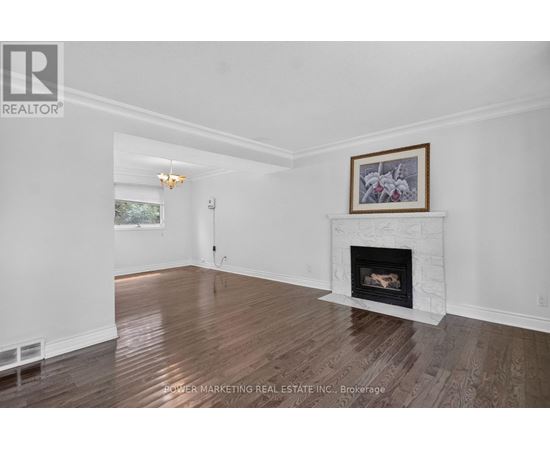 A living room with a fireplace and a painting above it.