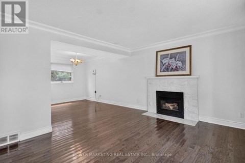 A living room with a fireplace and a painting above it.