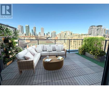 A patio with a couch, chairs and a table with a view of the city.