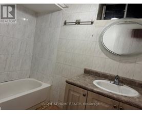 A bathroom with a tub, sink, and mirror.