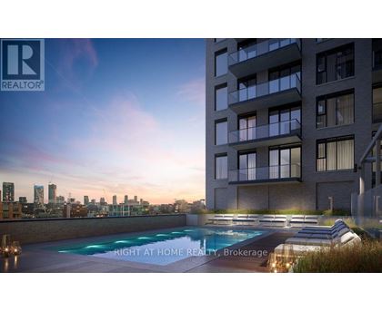A modern apartment building with a pool and lounge chairs on the roof.