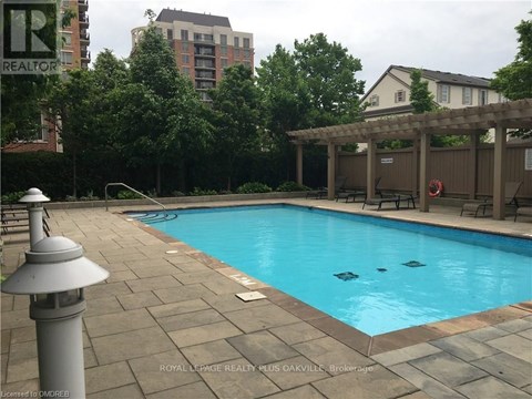A pool surrounded by a patio and trees.