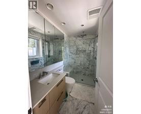 A bathroom with marble tiles and a walk-in shower.