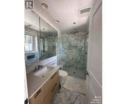 A bathroom with marble tiles and a walk-in shower.