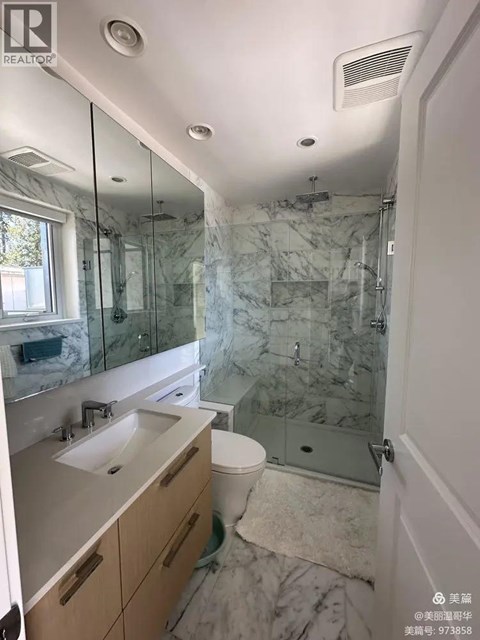 A bathroom with marble tiles and a walk-in shower.