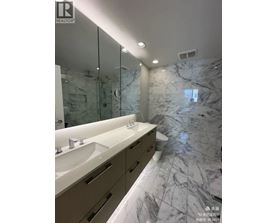 A bathroom with marble floors and a large mirror.