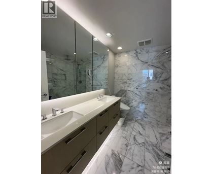 A bathroom with marble floors and a large mirror.