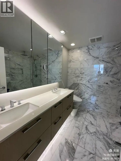 A bathroom with marble floors and a large mirror.