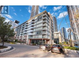 A modern apartment building with cars parked in front.
