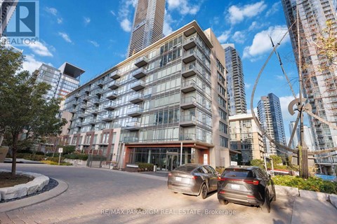 A modern apartment building with cars parked in front.