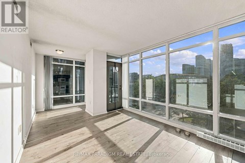 A room with a view of the city through large windows.