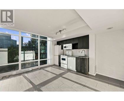 A kitchen with a white fridge, microwave, and oven in a modern apartment.