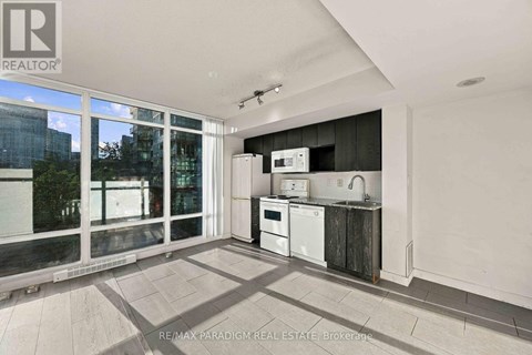 A kitchen with a white fridge, microwave, and oven in a modern apartment.
