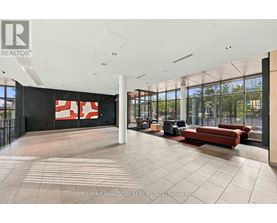 A large open space with a black wall and a red and white sign.