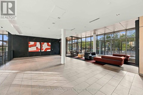 A large open space with a black wall and a red and white sign.