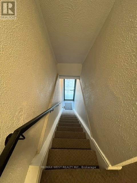 A stairway with a black handrail leading to a door at the top.