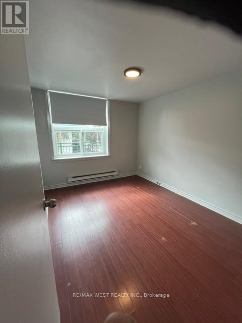 A room with a window and a wooden floor.