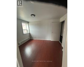 A room with a wooden floor and white walls.