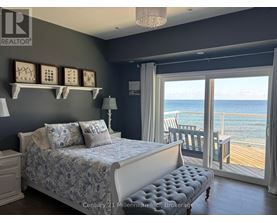 A bedroom with a large bed and a view of the ocean.