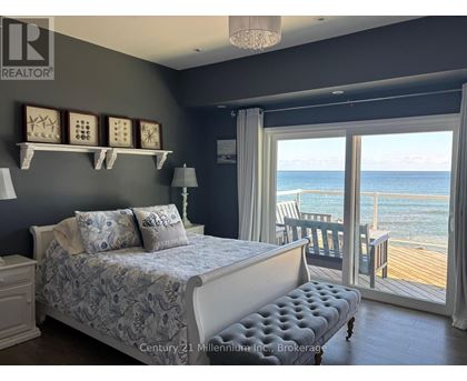 A bedroom with a large bed and a view of the ocean.