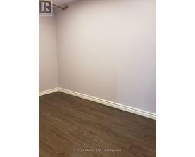 A room with wooden flooring and white walls.