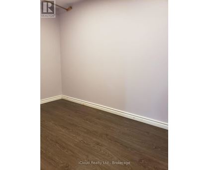 A room with wooden flooring and white walls.