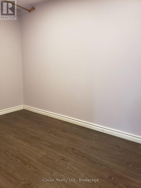 A room with wooden flooring and white walls.