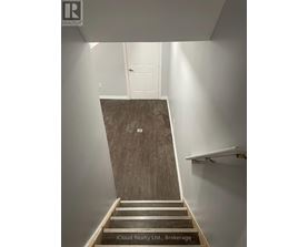A staircase with wooden steps and a white wall.