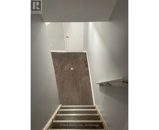 A staircase with wooden steps and a white wall.