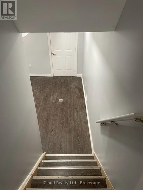 A staircase with wooden steps and a white wall.