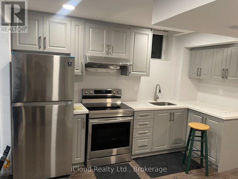 A kitchen with a stainless steel refrigerator and a stove top oven.