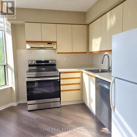 A kitchen with a white fridge, stove and oven.